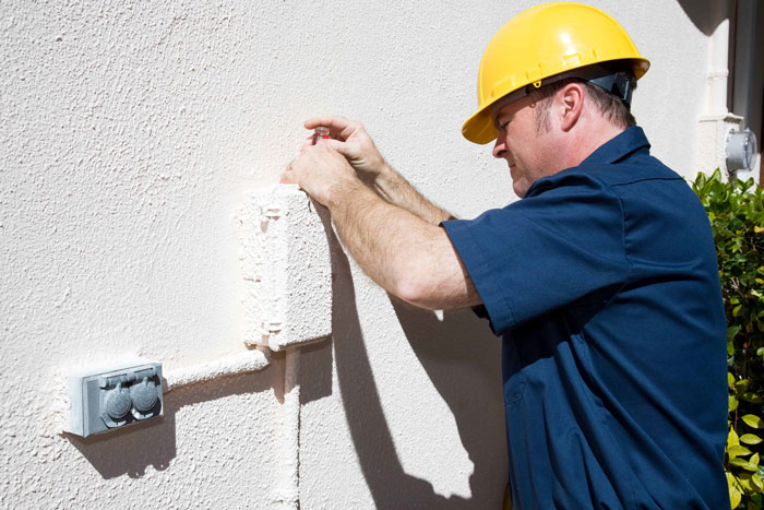 man working on electrical outlet